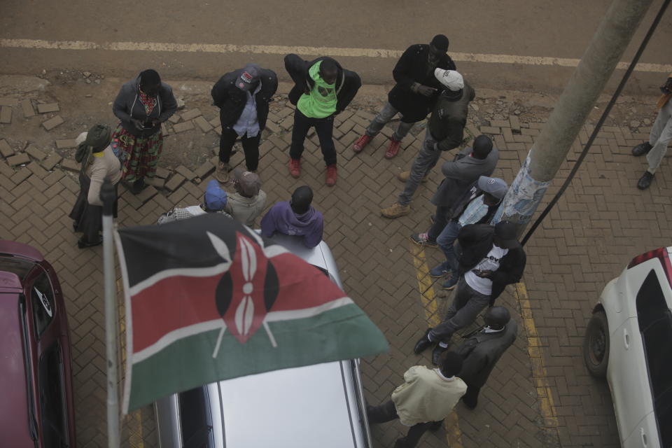 People wait for results outside a polling station in Eldoret, Kenya, Wednesday Aug. 10, 2022. Kenyans voted to choose between opposition leader Raila Odinga Deputy President William Rutoto succeed President Uhuru Kenyatta after a decade in power. (AP Photo/Brian Inganga)