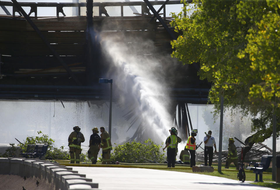 Local firefighters attempt to put out a fire on a derailed freight train on a bridge spanning Tempe Town Lake Wednesday, July 29, 2020, in Tempe, Ariz. (AP Photo/Ross D. Franklin)