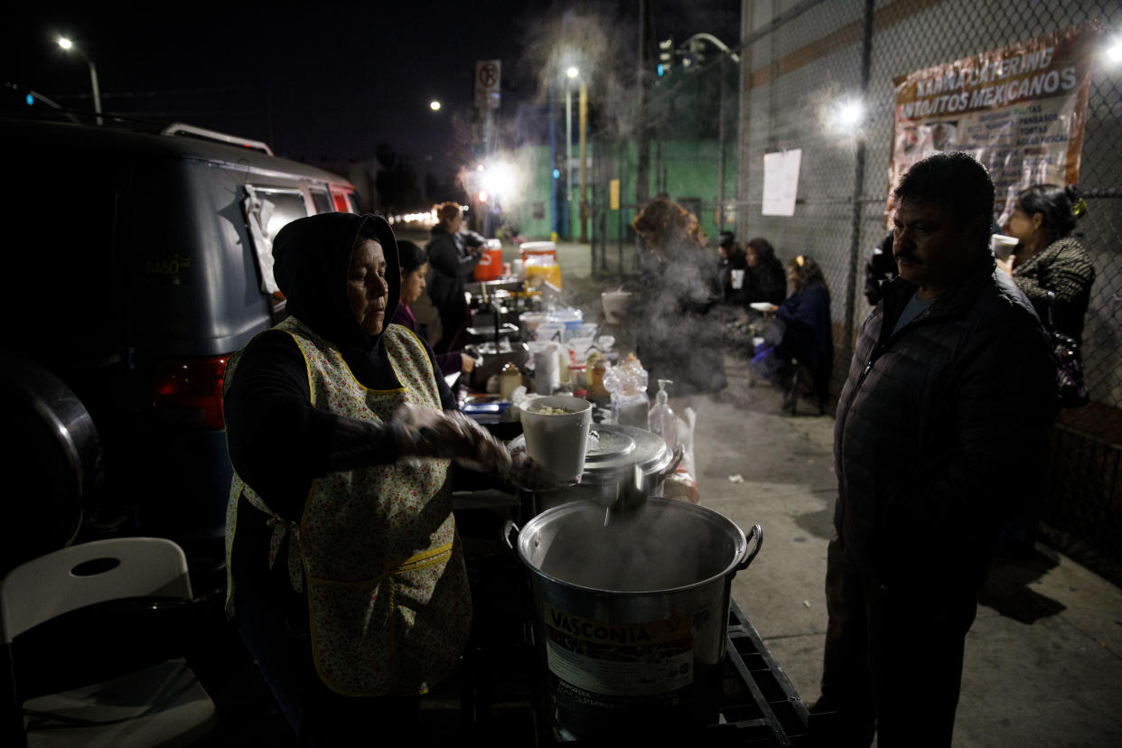 A food vendor of more than a decade serves pozole from a sidewalk grill in February in Boyle Heights, Los Angeles. (Photo: Patrick T. Fallon for Yahoo News)