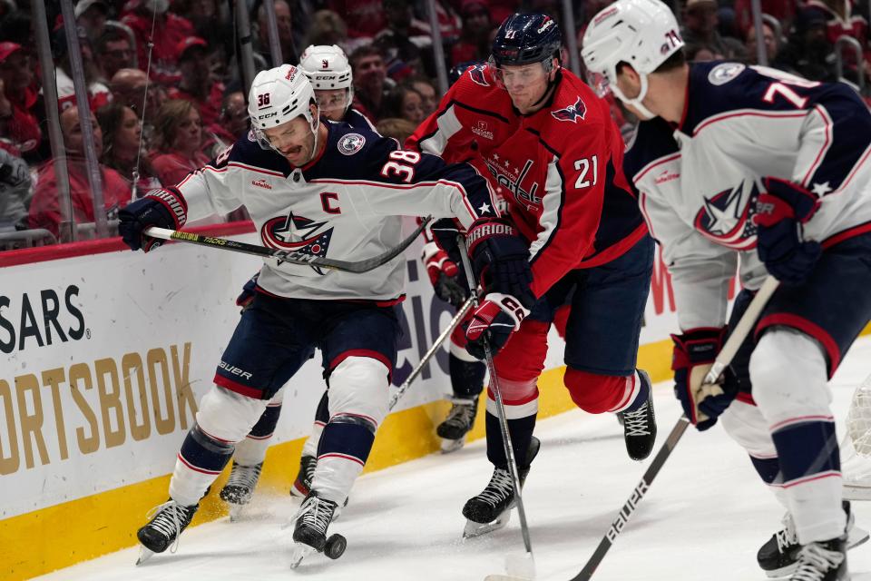 Columbus Blue Jackets center Boone Jenner (38) and Washington Capitals center Aliaksei Protas (21) battle for the puck during the first period of an NHL hockey game in Washington, Saturday, Nov. 18, 2023. Columbus Blue Jackets defenseman Damon Severson (78) tries to help at right. (AP Photo/Susan Walsh)