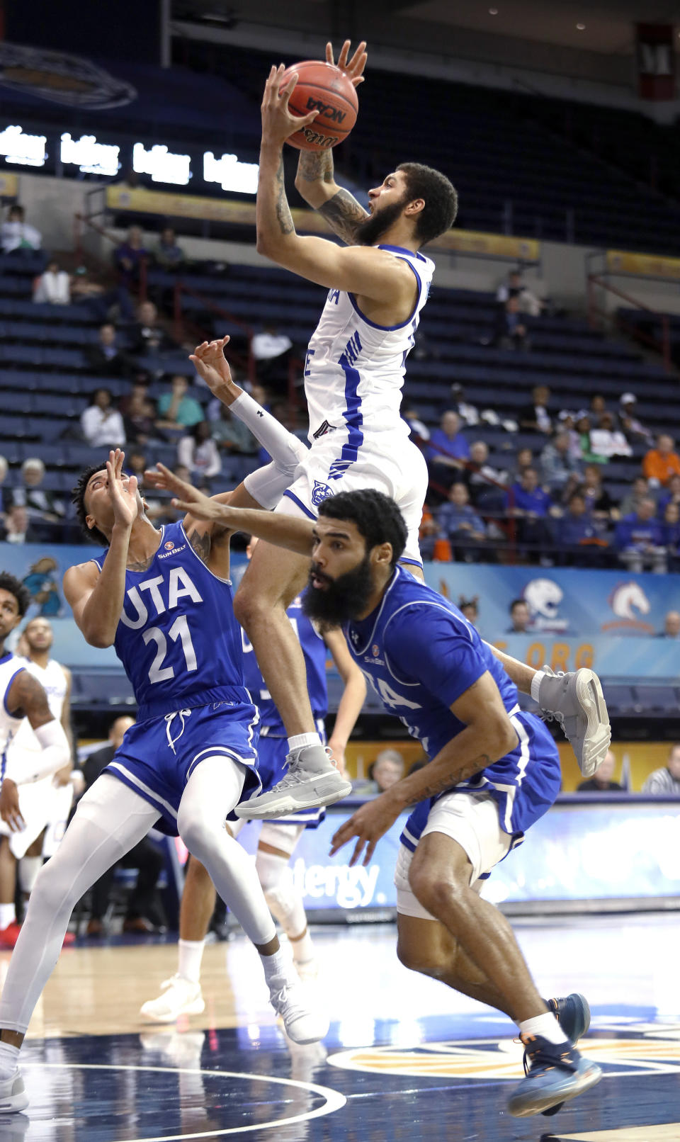 Georgia State guard D'Marcus Simonds (15) goes up to the basket between Texas-Arlington guards Pedro Castro (21) and Brian Warren during the second half of an NCAA college basketball game for the Sun Belt Conference men's tournament championship in New Orleans, Sunday, March 17, 2019. Georgia State won 73-64. (AP Photo/Tyler Kaufman)