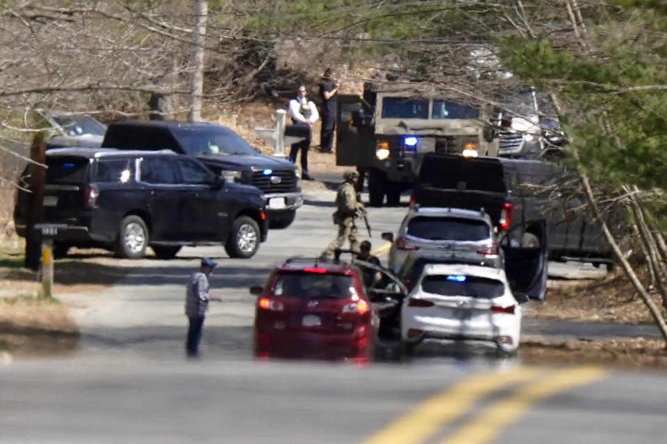 Members of law enforcement assemble on a road, Thursday, April 13, 2023, in Dighton, Mass., near where FBI agents converged on the home of a Massachusetts Air National Guard member who has emerged as a main person of interest in the disclosure of highly classified military documents on the Ukraine. (AP Photo/Steven Senne)