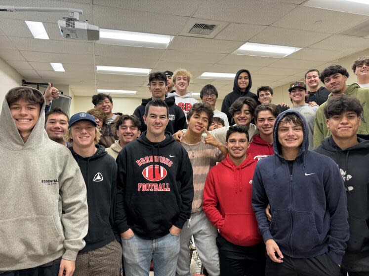 Burroughs coach Jesse Craven is surrounded by players from his Pacific League championship team on Saturday morning.