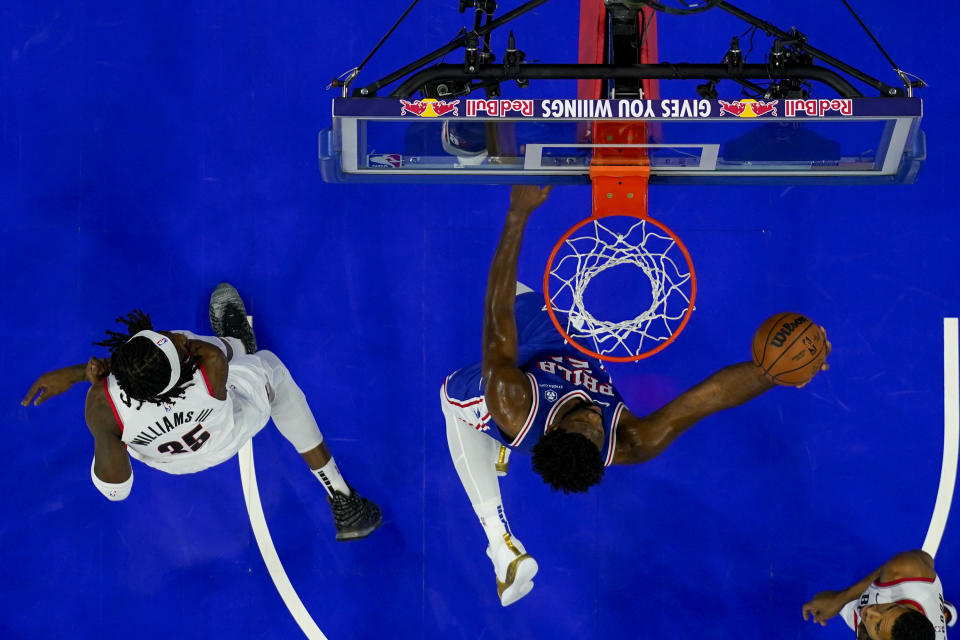 Philadelphia 76ers' Joel Embiid, right, goes up for the shot with Portland Trail Blazers' Robert Williams III, left, defending during the first half of an NBA basketball game, Sunday, Oct. 29, 2023, in Philadelphia. (AP Photo/Chris Szagola)