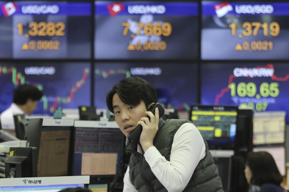 A currency trader talks on phone at the foreign exchange dealing room of the KEB Hana Bank headquarters in Seoul, South Korea, Wednesday, Feb. 5, 2020. Asian shares rose Wednesday on optimism that China's latest actions may help curtail some of the expected economic damage from the virus outbreak. (AP Photo/Ahn Young-joon)