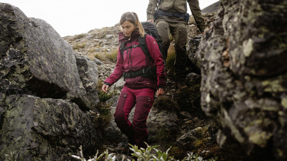 A women descends a rocky slope in Fjallraven Keb trousers