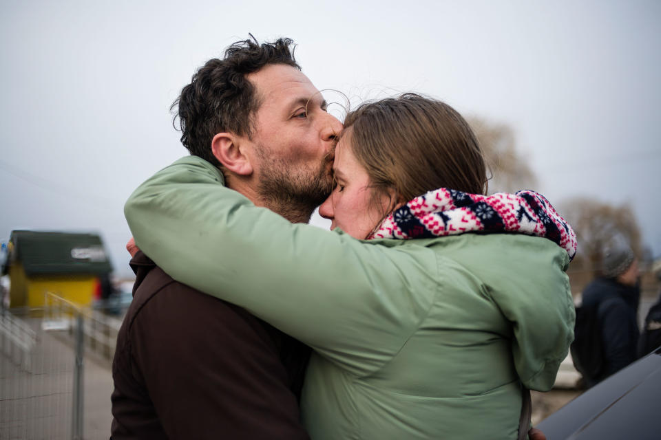 A couple hugs after finding their relatives waiting for them (Attila Husejnow / SOPA/LightRocket via Getty)