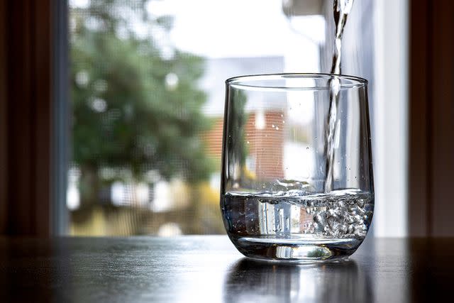 <p>Getty</p> A glass with water being poured into it