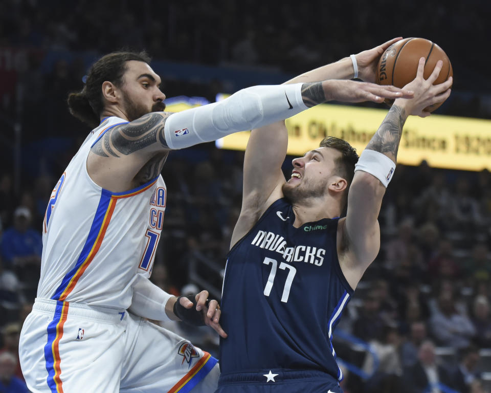 Oklahoma City Thunder center Steven Adams (12) tries to get the ball from Dallas Mavericks guard Luka Doncic (77) in the first half of an NBA basketball game, Monday, Jan. 27, 2020, in Oklahoma City. (AP Photo/Kyle Phillips)