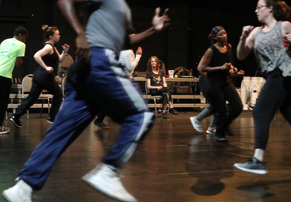 Choreographer/director Kimberly Bartosik, seated center, watches during a rehearsal for "The Encounter: Akron" in University of Akron's Sandefur Theatre in Guzzetta Hall.