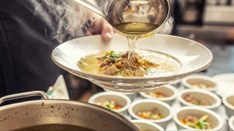 Ladle pouring soup into bowl