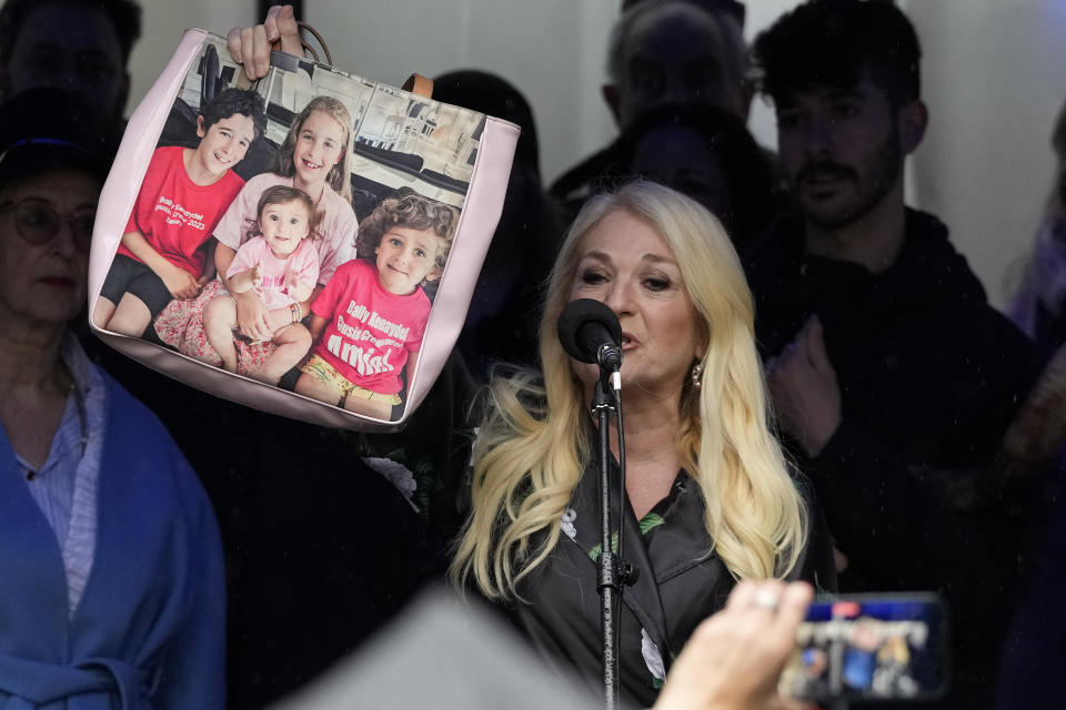 Vanessa Feltz, English TV personality and broadcaster, holds a bag picturing her grandchildren as Jewish people and sympathisers gather, in London, Sunday, March 10, 2024, The group blew shofars (ram's horns of spiritual significance) and whistles to show solidarity with the 100 plus hostages held in Gaza. The 'blow' lasted for 1.55 minutes marking the 155 days they have spent in captivity. (AP Photo/Frank Augstein)