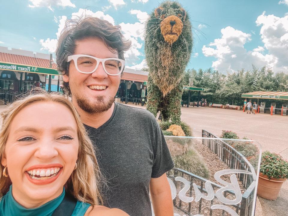 kayleigh and friend posing by the busch gardens lion at the front of the park