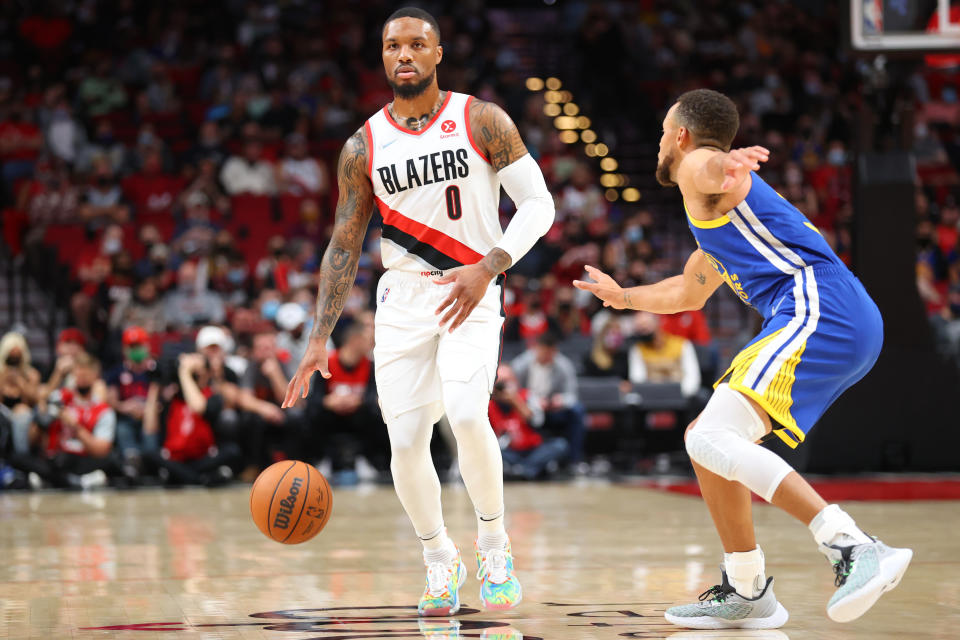 PORTLAND, OREGON - OCTOBER 04: Damian Lillard #0 of the Portland Trail Blazers handles the ball against Stephen Curry #30 of the Golden State Warriors in the first quarter during the preseason game at Moda Center on October 04, 2021 in Portland, Oregon. NOTE TO USER: User expressly acknowledges and agrees that, by downloading and or using this photograph, User is consenting to the terms and conditions of the Getty Images License Agreement.  (Photo by Abbie Parr/Getty Images)