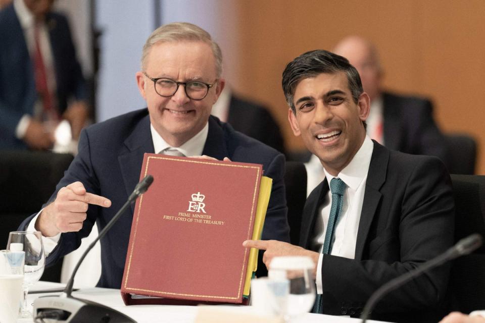 Australia's prime Minister Anthony Albanese (L) holds British prime minister Rishi Sunak's ministerial folder at a working session during the G7 Leaders' Summit in Hiroshima (POOL/AFP via Getty Images)