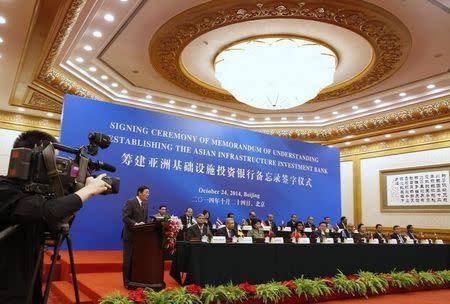 China's Finance Minister Lou Jiwei (L) gives a speech, with the guests of the signing ceremony of the Asian Infrastructure Investment Bank at the Great Hall of the People in Beijing October 24, 2014. REUTERS/Takaki Yajima/Pool