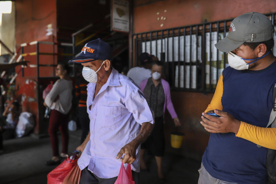 Passengers wearing masks to protect against the spread of the new coronavirus, get ready to board a bus at the Mayoreo market in Managua, Nicaragua, Tuesday, April 7, 2020. Restaurants are empty, there's little traffic in the streets and beach tourists are sparse headed into Holy Week despite the government's encouragement for Nicaraguans to go about their normal lives. (AP Photo/Alfredo Zuniga)