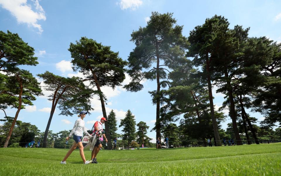 Nelly Korda of Team United States walks off the 18th tee with caddie Jason McDede during the third round of the Women's Individual Stroke Play on day fourteen of the Tokyo 2020 Olympic Games at Kasumigaseki Country Club on August 06, 2021 in Kawagoe, Japan. - Mike Ehrmann/Getty Images