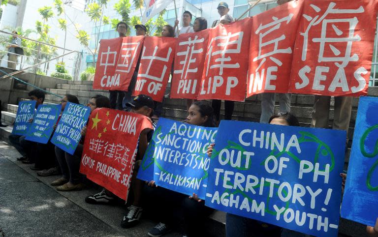 Filipino activists display placards during a rally outside China's consular office in Manila on May 11, 2015