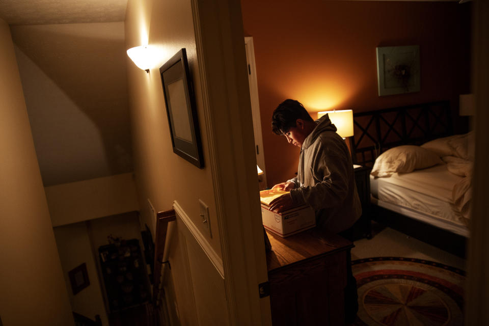 Andrea, 20, a transgender asylum seeker from Guatemala, sorts through documents as she settles in for the night at the home of a volunteer after her bond release from four months detained at the Stewart Detention Center, Tuesday, Nov. 12, 2019, in Columbus, Ga. Without any family in the area, Andrea would board a bus the next morning for the 23 hour bus ride to see her father in New York. (AP Photo/David Goldman)