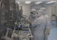 Employees in PPE work inside a lab where the HPV vaccine is produced at the Serum Institute of India, in Pune