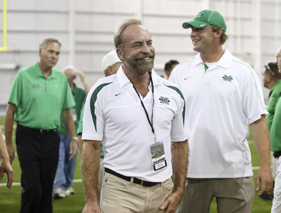 In this Sept. 6, 2014 photo shows Chris Cline, center, Chad Pennington, right, and Mike D'Antoni, left, arrive as Marshall University dedicates the new indoor practice facility as the Chris Cline Athletic Complex in Huntington, W.Va. Police in the Bahamas say a helicopter flying from Big Grand Cay island to Fort Lauderdale has crashed, killing seven Americans on board. None of the bodies recovered from the downed helicopter have been identified, but police Supt. Shanta Knowles told The Associated Press on Friday, July 5, 2019, that the missing-aircraft report from Florida said billionaire Chris Cline was on board. (Sholten Singer/The Herald-Dispatch via AP)