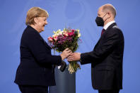 New elected German Chancellor Olaf Scholz, right, gives flowers to former Chancellor Angela Merkel during a handover ceremony in the chancellery in Berlin, Wednesday, Dec. 8, 2021. (Photo/Markus Schreiber)