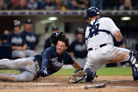 Jun 5, 2018; San Diego, CA, USA; Atlanta Braves shortstop Dansby Swanson (left0 scores ahead of the tag from San Diego Padres catcher A.J. Ellis (right) on a double by second baseman Ryan Flaherty (not pictured) during the seventh inning at Petco Park. Mandatory Credit: Jake Roth-USA TODAY Sports