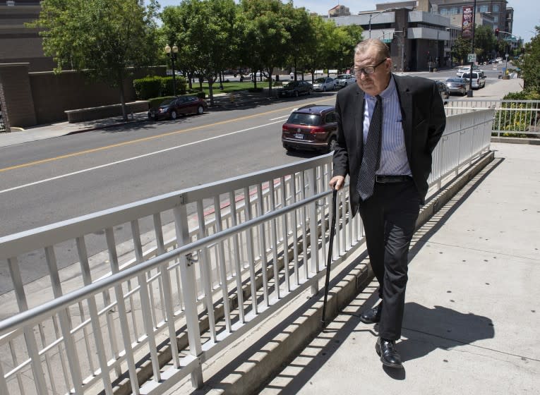 Modesto attorney Frank Carson uses a cane to walk up the ramp to court.