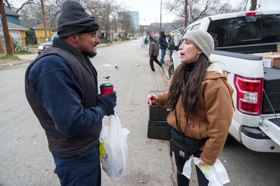 Ari Vinograd of Our Shared Kitchen talks with Shane Urich after providing him with a meal Monday. "A lot of people really need help in Austin," she said.