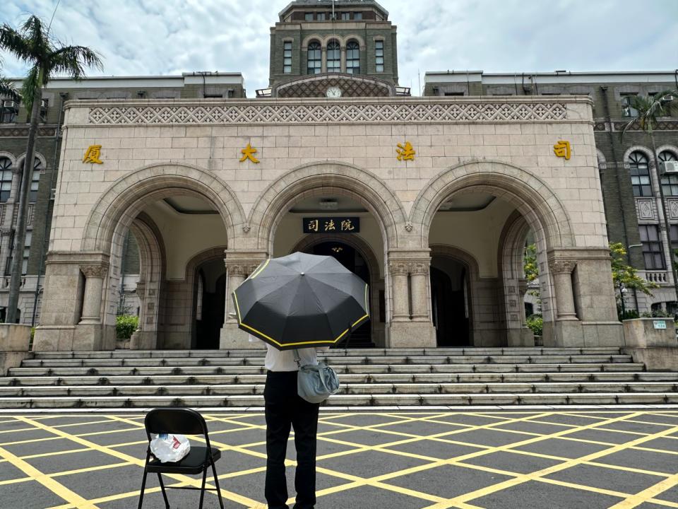 基隆地院法官李岳手捧白花、撐黑雨傘，一早就獨站司法院門口。侯柏青攝