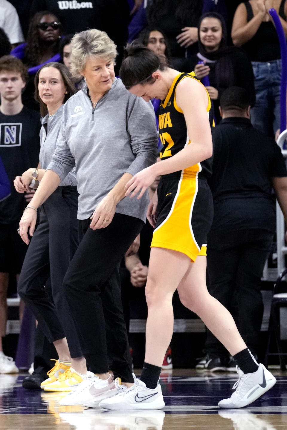 Iowa head coach Lisa Bluder, left, talks with guard Caitlin Clark as they walk to the bench after Caitlin Clark fell down during the second half of an NCAA college basketball game against Northwestern in Evanston, Ill., Wednesday, Jan. 31, 2024. Iowa won 110-74. (AP Photo/Nam Y. Huh)