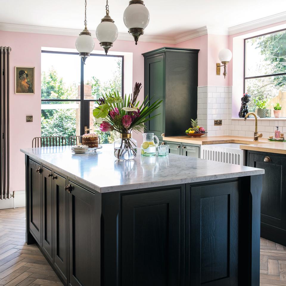 Navy kitchen with island and pink wall.