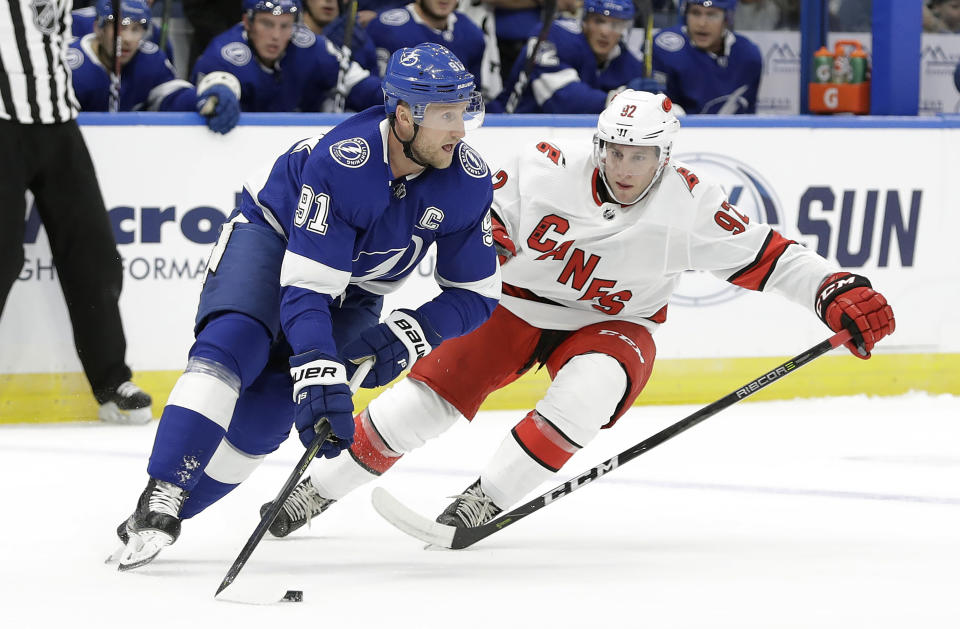 Tampa Bay Lightning center Steven Stamkos (91) looks to pass the puck around Carolina Hurricanes forward Colin Markison (92) during the first period of an NHL preseason hockey game Tuesday, Sept. 17, 2019, in Tampa, Fla. (AP Photo/Chris O'Meara)