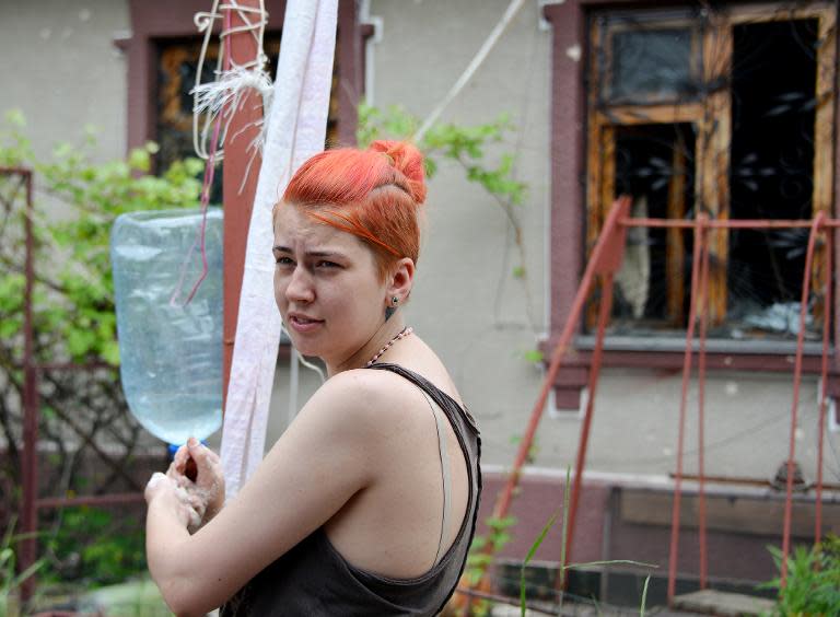 Ukrainian medical student Nika washes her hands before giving first aid to a wounded soldier in the village of Piski, on May 28, 2015