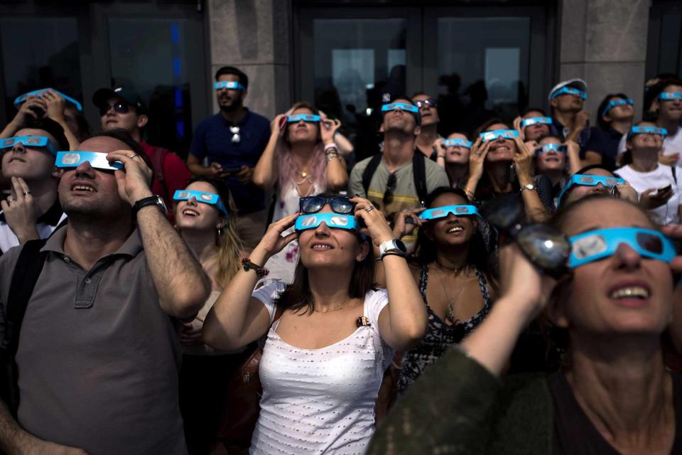<p>Drew Angerer/Getty</p> People watching the solar eclipse in New York City