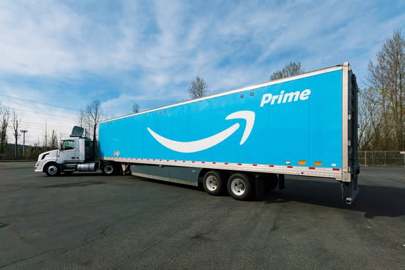 Semi truck with a white Amazon Prime logo on its sky blue trailer.