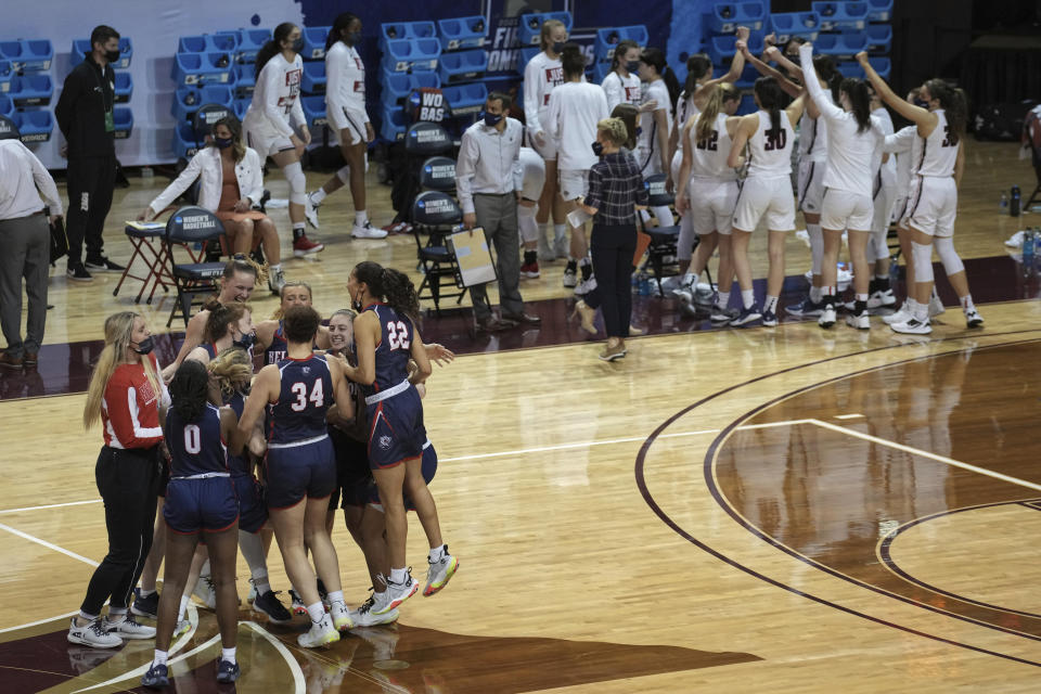 Belmont players, left, celebrate after a win over Gonzaga, background, in a college basketball game in the first round of the NCAA women's tournament at the University Events Center in San Marcos, Texas, Monday, March 22, 2021. (AP Photo/Chuck Burton)