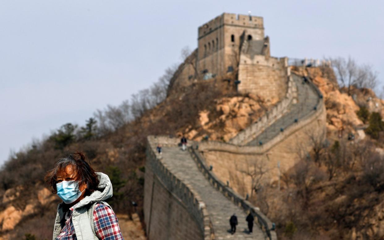 A woman wearing a protective face mask visits the Badaling Great Wall of China after it reopened for business following the new coronavirus outbreak in Beijing - AP