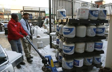 Employee Michael Torney (L) moves a pallet of propane gas tanks at Strosniders Hardware store in Silver Spring, Maryland January 21, 2016. REUTERS/Gary Cameron