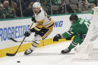 Pittsburgh Penguins left wing Zach Aston-Reese (12) skates with the puck against Dallas Stars right wing Alexander Radulov (47) during the first period of an NHL hockey game in Dallas, Saturday, Jan. 8, 2022. (AP Photo/LM Otero)