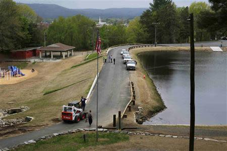 Workers put the finishing touches on the earthen dam at Robinhood Park Reservoir in Keene, New Hampshire May 16, 2014. Residents of this city of 23,000 people have faced repeated flooding in recent years including three floods considered 100-year events in the past decade alone. REUTERS/Brian Snyder