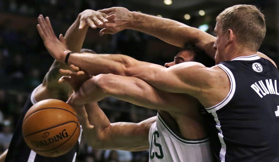 Boston Celtics center Kris Humphries loses control of the ball as he is sandwiched between Brooklyn Nets forward Mason Plumlee, right, and guard Deron Williams during the first quarter of an NBA basketball game, Friday, March 7, 2014, in Boston. (AP Photo/Charles Krupa)