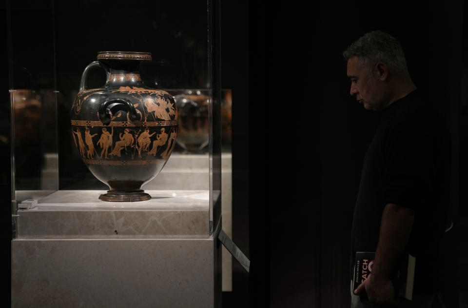 A man observes the ancient Greek vase from 420 BC – the Meidias Hydria – on loan from the British Museum, during a media tour ahead of the Greece's Acropolis Museum officially launched of the exhibition, 'Meanings' Personifications and Allegories From Antiquity to Today, in Athens, Tuesday, Dec. 5, 2023. The loan coincides with a spat between the two countries over Greek demands for the return of sculptures from the Parthenon temple on the Acropolis that are housed in the British Museum. (AP Photo/Thanassis Stavrakis)