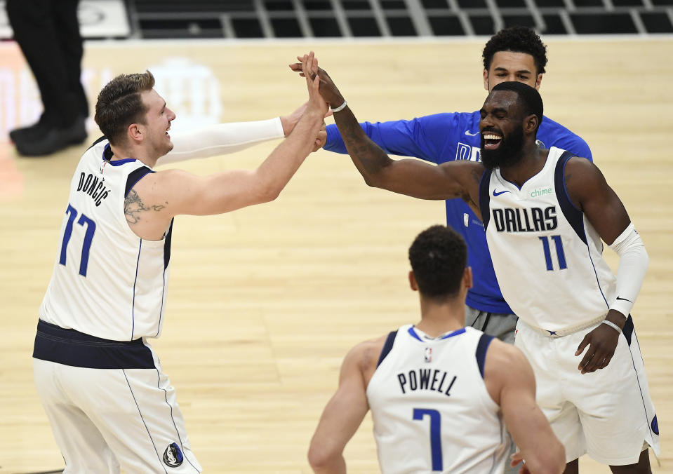 Luka Doncic of the Dallas Mavericks is congratulated by Tim Hardaway Jr.