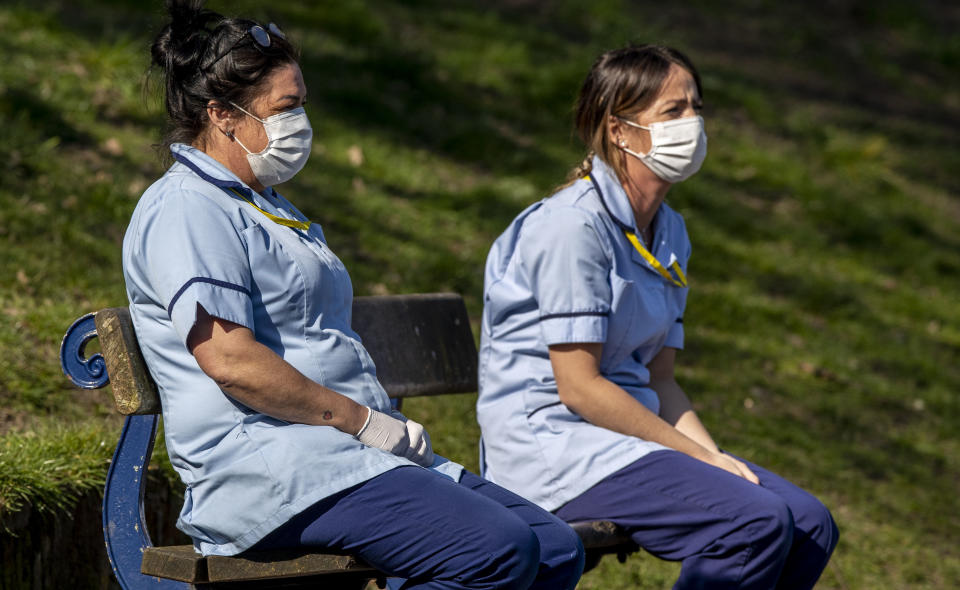 Care workers Carla Martin and Michelle McNicholas take a break from their work and sit on a bench in Sefton Park, Liverpool after Prime Minister Boris Johnson has put the UK in lockdown to help curb the spread of the coronavirus. PA Photo. Picture date: Thursday March 26, 2020. The UK's coronavirus death toll reached 463 on Wednesday. See PA story HEALTH Coronavirus. Photo credit should read: Peter Byrne/PA Wire