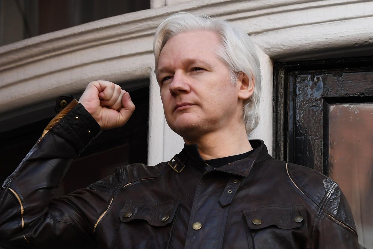 Wikileaks founder Julian Assange raises his fist prior to addressing the media on the balcony of the Embassy of Ecuador in London in 2017: AFP via Getty Images