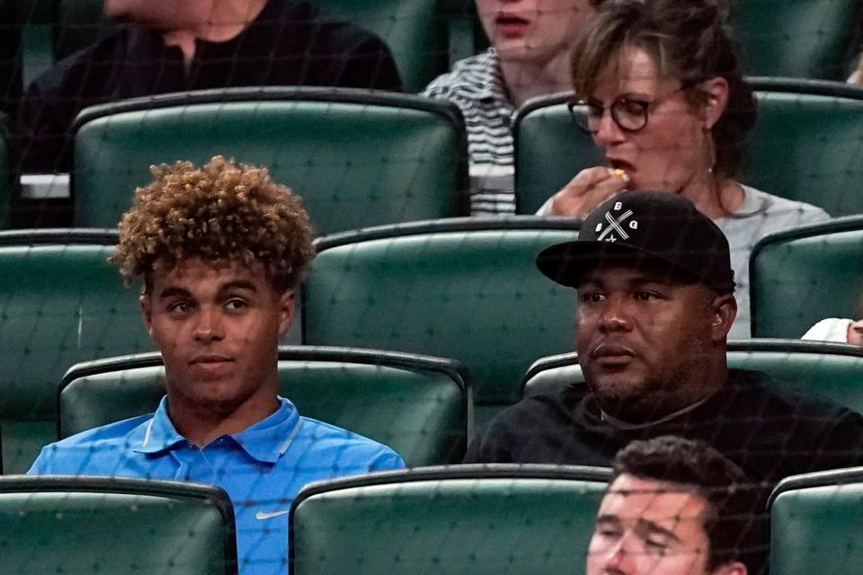 Former Atlanta Braves outfielder Andruw Jones (right), sits with his son Druw during a baseball game between Oakland Athletics and the Braves Tuesday, June 7, 2022, in Atlanta.