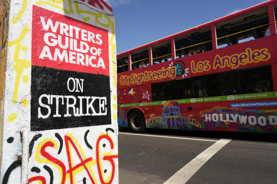 A tour bus passes a picket sign outside Paramount studios on Wednesday, July 26, 2023, in Los Angeles. The actors strike comes more than two months after screenwriters began striking in their bid to get better pay and working conditions. (AP Photo/Chris Pizzello)