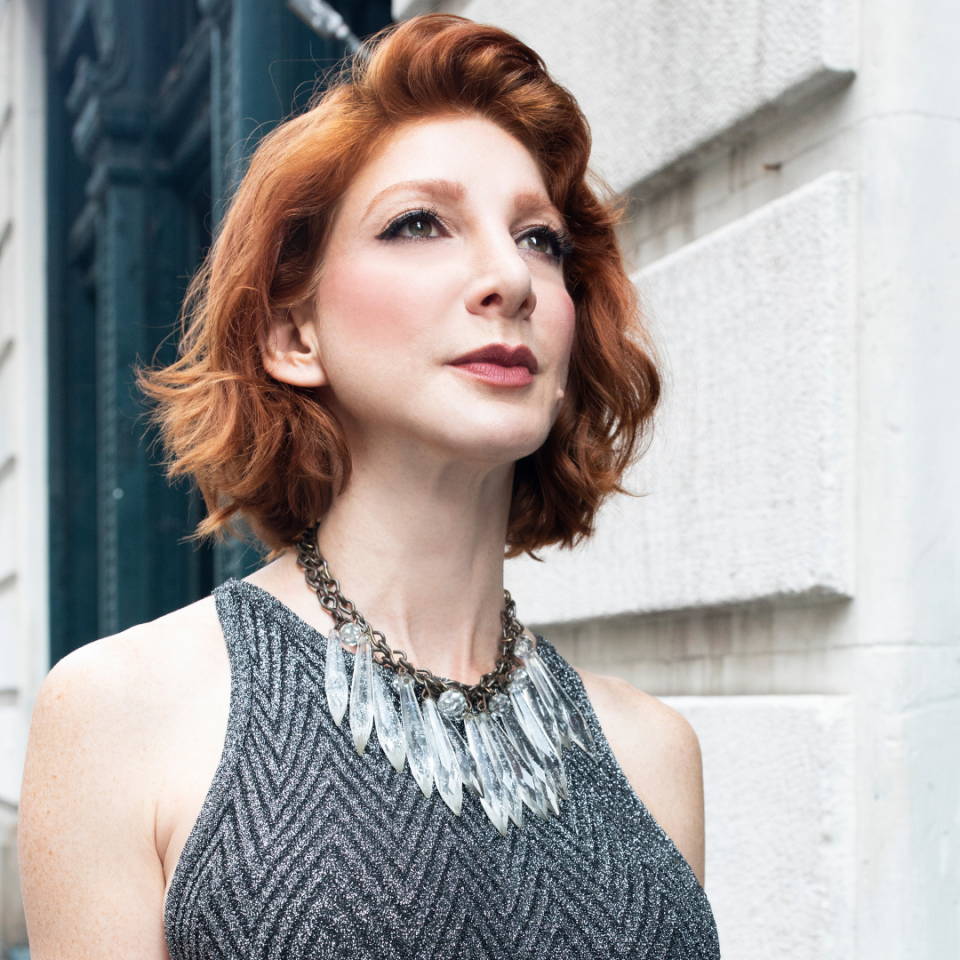 Rebecca Gordon wearing a sparkly dress and a statement necklace, posing outdoors